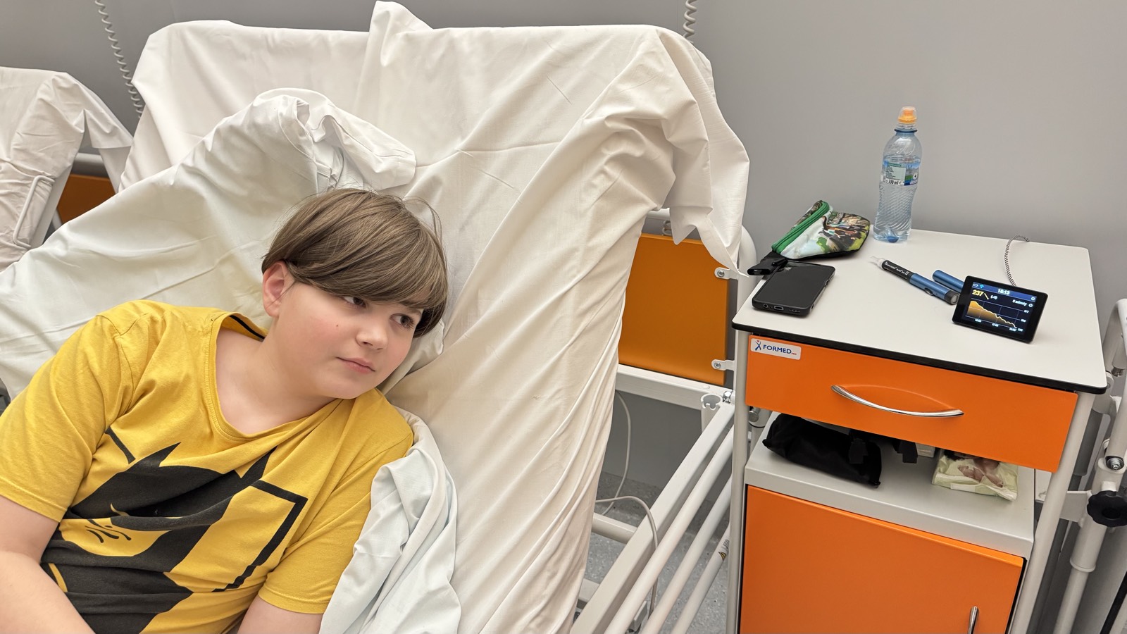 Dziecko na łóżku szpitalnym obok stolika z GlucoLantern